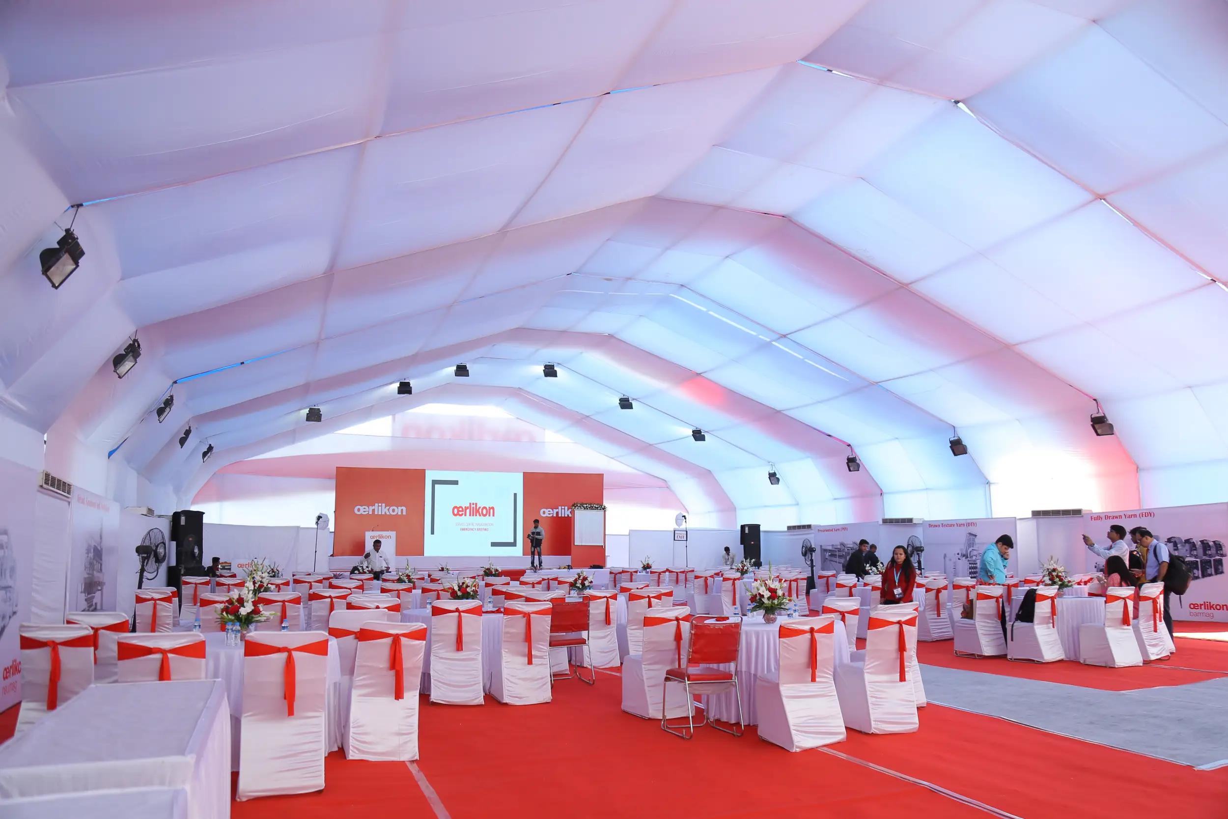 ITT event entrance with red and green carpet and pink lighting on white structure with ITT branding